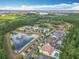 A scenic aerial view of the community showcasing lush greenery, a pond, and well-maintained homes under a partly cloudy sky at 8530 Vivaro Isle Way, Windermere, FL 34786