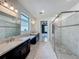 Modern bathroom with double sinks, a frameless glass shower, and tile flooring, providing a luxurious experience at 8530 Vivaro Isle Way, Windermere, FL 34786