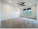 Bedroom with ceiling fan and two windows overlooking outdoor landscape at 8530 Vivaro Isle Way, Windermere, FL 34786