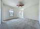 Large bedroom featuring two windows, neutral carpet, a ceiling fan, and ample space, providing a comfortable retreat at 8530 Vivaro Isle Way, Windermere, FL 34786