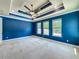 Bright bedroom featuring a tray ceiling with recessed lighting, a ceiling fan, and three large windows at 8530 Vivaro Isle Way, Windermere, FL 34786