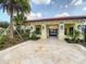 Gated community entrance with tile roof, stone columns, and wrought iron gates, surrounded by palm trees and landscaping at 8530 Vivaro Isle Way, Windermere, FL 34786