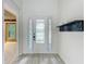 Bright entryway with glass-paneled front door and coat rack, complemented by light-colored floors at 8530 Vivaro Isle Way, Windermere, FL 34786