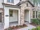 Charming front entrance with stone accents, covered porch, and well-maintained landscaping at 8530 Vivaro Isle Way, Windermere, FL 34786