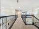Second floor hallway with carpet, decorative railing, and views of the living room below, creating an open atmosphere at 8530 Vivaro Isle Way, Windermere, FL 34786