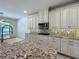 Bright kitchen featuring granite countertops, stainless steel microwave, and patterned backsplash at 8530 Vivaro Isle Way, Windermere, FL 34786