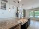 Open concept living space highlights kitchen island with granite counters and sink at 8530 Vivaro Isle Way, Windermere, FL 34786