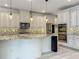 Open kitchen boasts granite countertops, stainless appliances, and pendant lighting at 8530 Vivaro Isle Way, Windermere, FL 34786