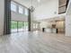 Bright open-concept living room features high ceilings, tile floors, and a modern kitchen with backyard pool access at 8530 Vivaro Isle Way, Windermere, FL 34786