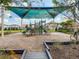Community playground featuring shaded play structures, a slide, and seating area, surrounded by lush landscaping at 8530 Vivaro Isle Way, Windermere, FL 34786