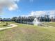 Scenic community pond with a fountain surrounded by lush green grass and mature trees, perfect for relaxation at 8530 Vivaro Isle Way, Windermere, FL 34786