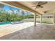 Covered patio featuring travertine flooring, ceiling fans, and a view of the pool with fountain at 8530 Vivaro Isle Way, Windermere, FL 34786