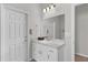 Bright bathroom with a single sink vanity and a door to the toilet and shower area at 8978 Se 42Nd Ct, Ocala, FL 34480