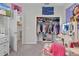 Well-organized closet and vanity in carpeted bedroom with door to laundry room at 8978 Se 42Nd Ct, Ocala, FL 34480