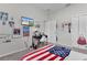 Decorated bedroom featuring a TV, desk and a bed with an American flag blanket at 8978 Se 42Nd Ct, Ocala, FL 34480