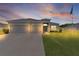 Exterior view of home with three-car garage under a dusk sky with beautiful cloud formations at 8978 Se 42Nd Ct, Ocala, FL 34480