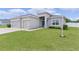 Inviting home exterior with a well-manicured lawn, tidy landscaping, and a spacious three-car garage at 8978 Se 42Nd Ct, Ocala, FL 34480