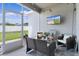 Screened lanai is furnished with comfortable seating, a television, and views of the backyard at 8978 Se 42Nd Ct, Ocala, FL 34480