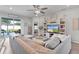Bright living room with a large sectional, decorative shelving, and a sliding door to the screened lanai at 8978 Se 42Nd Ct, Ocala, FL 34480