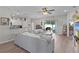Open living area with large sectional, decorative shelves, and views to the kitchen and screened lanai at 8978 Se 42Nd Ct, Ocala, FL 34480