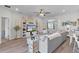 Open-concept living room features stylish decor, including a large sectional, built-in shelving, and wood-look floors at 8978 Se 42Nd Ct, Ocala, FL 34480