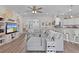 Comfortable living room with a large sectional sofa, decorative shelving, wood-look floors and a view of the kitchen at 8978 Se 42Nd Ct, Ocala, FL 34480