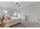 Large main bedroom featuring a tray ceiling, TV, dresser, and natural light from windows at 8978 Se 42Nd Ct, Ocala, FL 34480