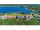 Aerial view of a waterfront property with lush greenery, neighboring houses, and a private dock at 9648 Weatherstone, Windermere, FL 34786