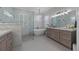 Luxurious bathroom with a soaking tub, marble details, and glass-enclosed shower at 9648 Weatherstone, Windermere, FL 34786