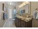 Bathroom featuring granite counters, wood cabinets, decorative mirror and a tiled floor at 9648 Weatherstone, Windermere, FL 34786