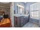 Bathroom featuring dark wood cabinets, granite countertops, and modern fixtures with natural light from the window at 9648 Weatherstone, Windermere, FL 34786