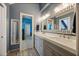 Bathroom featuring a double sink vanity with a decorative mirror and gray cabinets at 9648 Weatherstone, Windermere, FL 34786