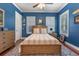Bedroom featuring blue walls, hardwood floors, and a ceiling fan at 9648 Weatherstone, Windermere, FL 34786