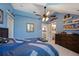 Blue bedroom with a ceiling fan, natural light, decor with a dresser at 9648 Weatherstone, Windermere, FL 34786