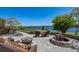 Inviting outdoor stone patio featuring wicker seating, fire pit, and tranquil lake views for relaxation and entertainment at 9648 Weatherstone, Windermere, FL 34786