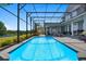 Sparkling blue pool with a screened enclosure and picturesque views of the landscaped backyard and lake at 9648 Weatherstone, Windermere, FL 34786