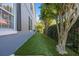 Side yard with green turf, mature trees and a black fence on a sunny day at 9648 Weatherstone, Windermere, FL 34786