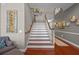 Bright staircase with wooden treads, white risers, and gray walls adorned with Gathering photos at 9648 Weatherstone, Windermere, FL 34786