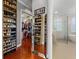 Spacious walk-in closet featuring custom shelving, hardwood floors, and a full length mirror at 9648 Weatherstone, Windermere, FL 34786