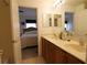 Open bathroom with double sink vanity and access to the main bedroom at 10115 Regent Park Dr # 2503, Orlando, FL 32825