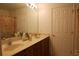 Bright bathroom featuring a double vanity with neutral toned countertop and wood cabinets at 10115 Regent Park Dr # 2503, Orlando, FL 32825