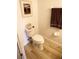 Half-bath with wood-look tile, toilet, and neutral walls, decorated with framed picture at 10115 Regent Park Dr # 2503, Orlando, FL 32825