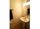 Half-bath with wood-look tile, pedestal sink, and neutral color scheme at 10115 Regent Park Dr # 2503, Orlando, FL 32825