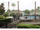 Resort-style pool area surrounded by palm trees, a pool house, black fencing, and manicured landscaping at 10115 Regent Park Dr # 2503, Orlando, FL 32825