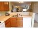 Open kitchen with stainless steel sink, dishwasher, wooden cabinets, and view to living area at 10115 Regent Park Dr # 2503, Orlando, FL 32825