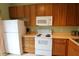 Bright kitchen featuring wooden cabinetry, white appliances, and a countertop with ample space at 10115 Regent Park Dr # 2503, Orlando, FL 32825