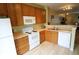 Efficient kitchen featuring oak cabinets, white appliances, and a wood-look floor, perfect for cooking enthusiasts at 10115 Regent Park Dr # 2503, Orlando, FL 32825