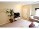 Bright living room featuring neutral carpet, a white front door, ample seating, and a decorative houseplant at 10115 Regent Park Dr # 2503, Orlando, FL 32825