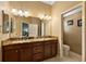 Bathroom with granite counter tops, double sinks and dark wood cabinetry at 1053 Alcove Loop, The Villages, FL 32162