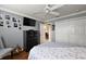 Inviting bedroom with light gray walls and dark furnishings, closet and mounted tv for storage and entertainment at 1053 Alcove Loop, The Villages, FL 32162